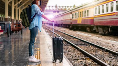 Solo sırt çantalı gezgin, Coronavirus krizinden sonra düşük maliyetli yaz tatili için güvenlik seyahati planlıyor. Tren istasyonunda boş bir turist. Sürdürülebilir çevre dostu ulaşım otobüsü kullan