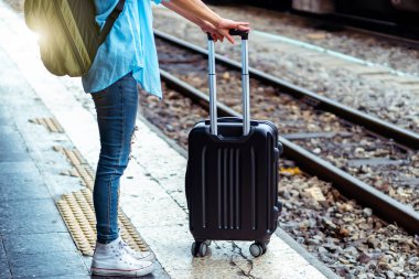 Solo sırt çantalı gezgin, Coronavirus krizinden sonra düşük maliyetli yaz tatili için güvenlik seyahati planlıyor. Tren istasyonunda boş bir turist. Sürdürülebilir çevre dostu ulaşım otobüsü kullan