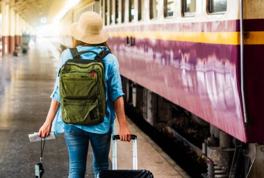 Tek başına gezen kadın Coronavirus 'tan sonra düşük maliyetli bir yaz tatili planlıyor. Tren istasyonunda boş bir turist. Sürdürülebilir çevre dostu ulaşım otobüsü kullan
