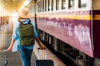 Tek başına gezen kadın Coronavirus 'tan sonra düşük maliyetli bir yaz tatili planlıyor. Tren istasyonunda boş bir turist. Sürdürülebilir çevre dostu ulaşım otobüsü kullan