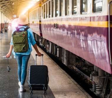 Tek başına gezen kadın Coronavirus 'tan sonra düşük maliyetli bir yaz tatili planlıyor. Tren istasyonunda boş bir turist. Sürdürülebilir çevre dostu ulaşım otobüsü kullan