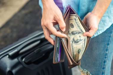 Sırt çantalı genç kadın gezgin ellerinde cüzdan dolar para planı tatil için bütçe tasarrufu ucuz indirim anlaşmaları Coronavirus 'un boş turizm krizinden sonra seyahat promosyon gezisi