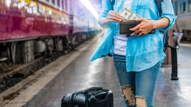 Sırt çantalı genç kadın gezgin ellerinde cüzdan dolar para planı tatil için bütçe tasarrufu ucuz indirim anlaşmaları Coronavirus 'un boş turizm krizinden sonra seyahat promosyon gezisi