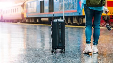 Tek başına gezen kadın Coronavirus 'tan sonra düşük maliyetli bir yaz tatili planlıyor. Tren istasyonunda boş bir turist. Sürdürülebilir çevre dostu ulaşım otobüsü kullan