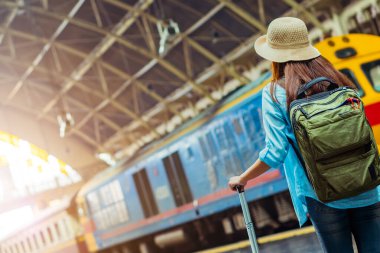 Tek başına gezen kadın Coronavirus 'tan sonra düşük maliyetli bir yaz tatili planlıyor. Tren istasyonunda boş bir turist. Sürdürülebilir çevre dostu ulaşım otobüsü kullan