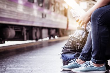Tek başına gezen kadın Coronavirus 'tan sonra düşük maliyetli bir yaz tatili planlıyor. Tren istasyonunda boş bir turist. Sürdürülebilir çevre dostu ulaşım otobüsü kullan