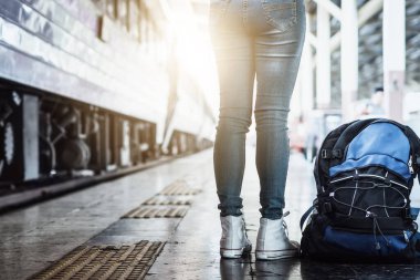 Tek başına gezen kadın Coronavirus 'tan sonra düşük maliyetli bir yaz tatili planlıyor. Tren istasyonunda boş bir turist. Sürdürülebilir çevre dostu ulaşım otobüsü kullan