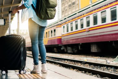 Tek başına gezen kadın Coronavirus 'tan sonra düşük maliyetli bir yaz tatili planlıyor. Tren istasyonunda boş bir turist. Sürdürülebilir çevre dostu ulaşım otobüsü kullan