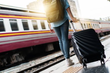 Tek başına gezen kadın Coronavirus 'tan sonra düşük maliyetli bir yaz tatili planlıyor. Tren istasyonunda boş bir turist. Sürdürülebilir çevre dostu ulaşım otobüsü kullan