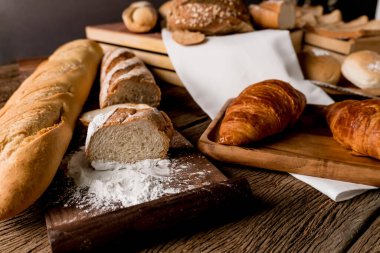 Çeşitli ev yapımı organik fırınlanmış hamur işleri (dilimlenmiş ekmek, tost, somun, kruvasan ve baget). Lezzetli sağlıklı vejetaryen yemeği için en iyisi satranç ve reçelle öğle yemeği