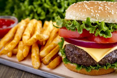Hamburger üzerinde susam tohumu çörek patates kızartması ile