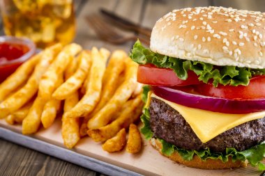 Hamburger üzerinde susam tohumu çörek patates kızartması ile