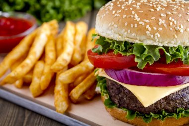 Hamburger üzerinde susam tohumu çörek patates kızartması ile