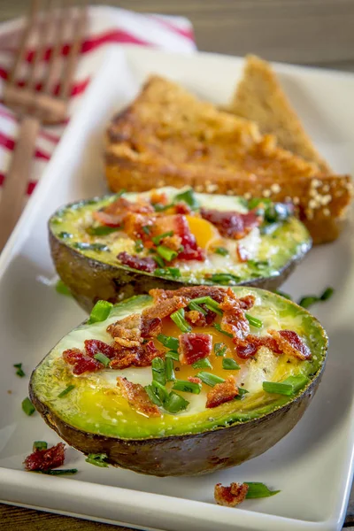 Baked avocados and eggs with bacon and chives