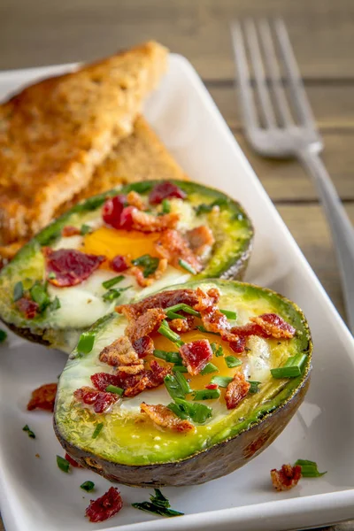 Bakad avokado och ägg med bacon och gräslök — Stockfoto
