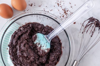Keto çikolatalı browni hamurunu cam kasede spatula ve çırpma iğnesiyle kapat.