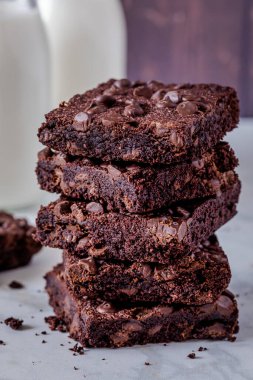Kestane çikolatalı browni yığınını iki şişe sütle birlikte koyu ahşap duvara kapatın.
