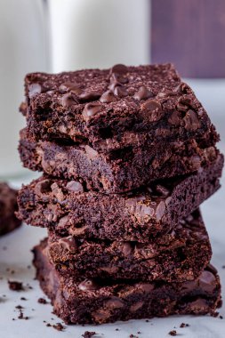 Kestane çikolatalı browni yığınını kapat. Koyu ahşap duvardan bir ısırık al.