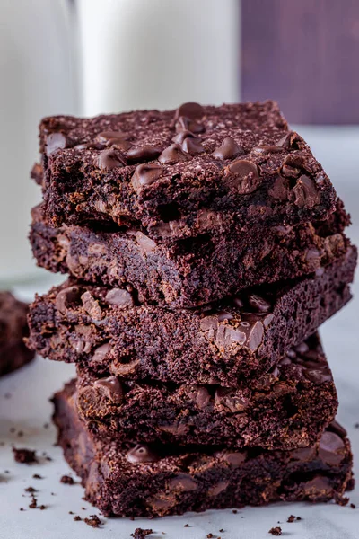 stock image Close up of stack of keto chocolate chip brownies with a bite taken out of one against dark wooden wall