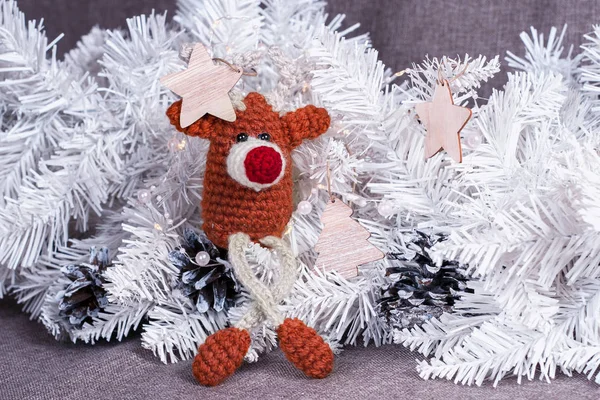 Christmas decor of crochet deer toy and christmas tree with cones