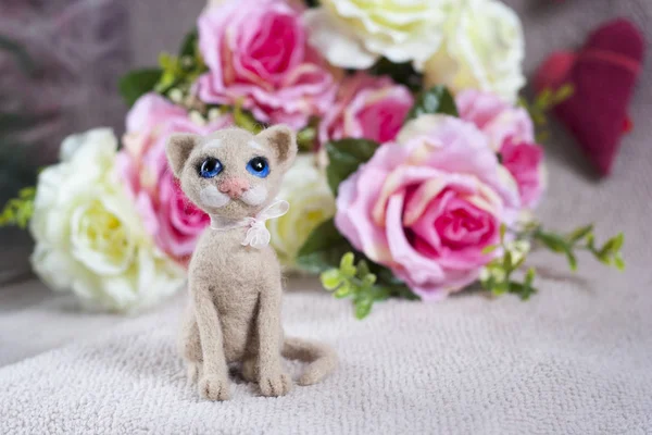 Toy cat and floral background