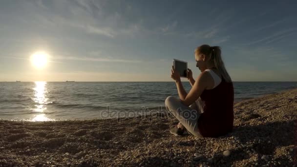 Jovem mulher tirando fotos na praia usando Tablet — Vídeo de Stock