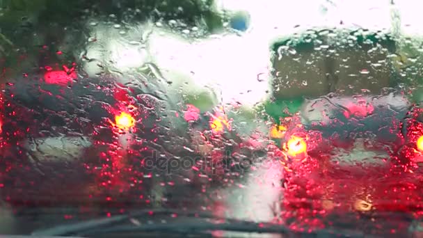 De auto gaat rond de stad, de regen op de voorruit is vochtig, de Wisserbladen werken — Stockvideo