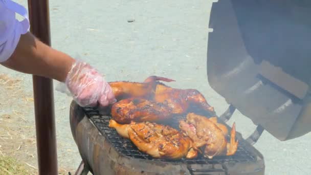 Повар жарит курицу на барбекю — стоковое видео