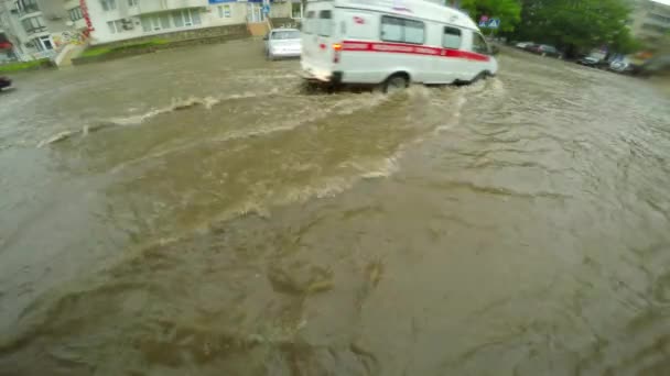 Coches están conduciendo a lo largo de una carretera inundada — Vídeo de stock