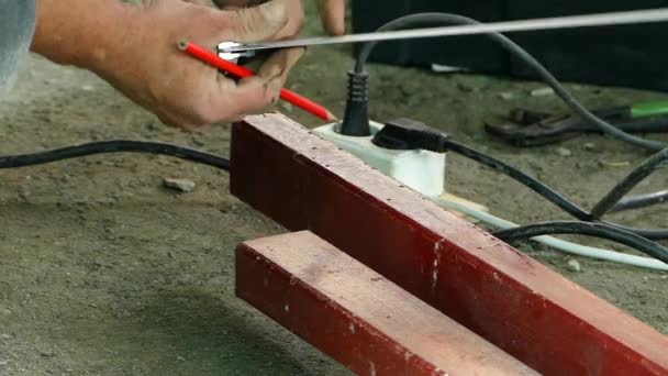 Ein Arbeiter macht Markierungen auf einer Metallstange. Zeitlupe. — Stockvideo