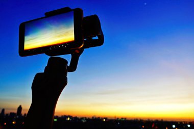 Akıllı telefonlarda mobil gimbal sabitleyici vardır takeing güzel günbatımı gökyüzü