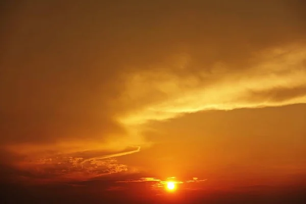 Um lapso de tempo do grande pôr-do-sol laranja enquanto o sol maciço se põe no horizonte acima da cidade — Fotografia de Stock