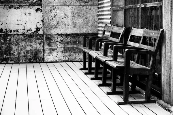 Černá a bílá staré dřevěné židle v staré dřevo místnosti staré železné zdi vintage — Stock fotografie