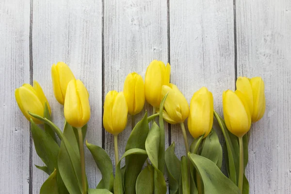 Gele tulpen op wit hout — Stockfoto