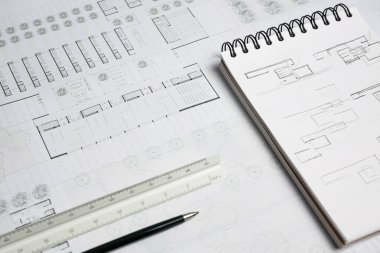 Mimari ölçek cetvel, mekanik kalem, defter ve çalışma tablosu üzerine bina planı
