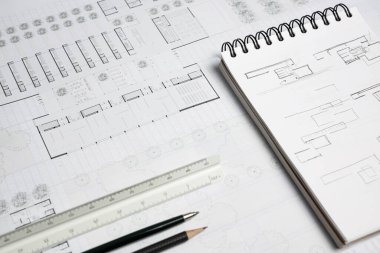 Mimari cetvel, kalem, mekanik kalem, defter ve çalışma tablosu üzerine bina planı
