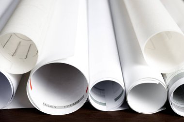 Mimari planlar ahşap bir masada yuvarlanıyor.