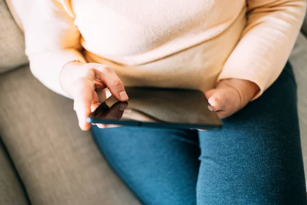 Old woman hands using a tablet. Old people with technology concept