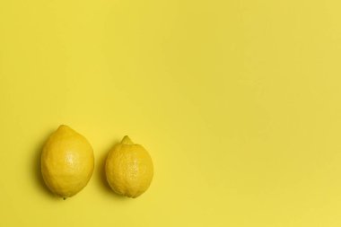 Sarı arka planda iki taze limon