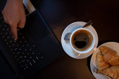 Laptop, kahve fincanı ve fırın kafenin en üst katında.