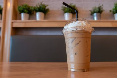 Soğuk kapuçino ve krem şanti hazır kahve fonda ahşap masada..