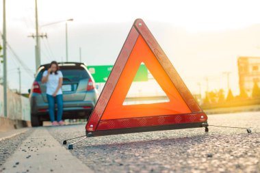 Yol kenarında kırık araba ile yardım çağrısı nda bulunan kadın, telefonla yardım çağrısında bulunan kadın.