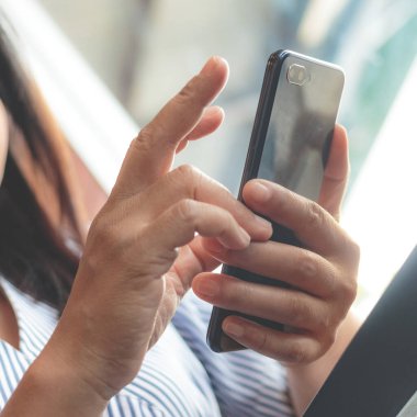 Bir kafede akıllı telefondan mesaj yazan bir kadın. 