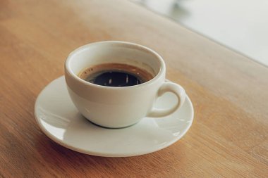 Kafedeki ahşap barda bir fincan kahve kapuçino..