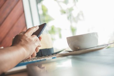 Bir kafede akıllı telefondan mesaj yazan bir kadın. 