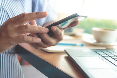 Bir kafede akıllı telefondan mesaj yazan bir kadın. 