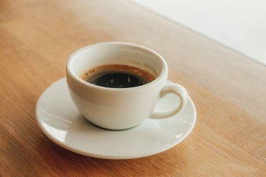 Kafedeki ahşap barda bir fincan kahve kapuçino..