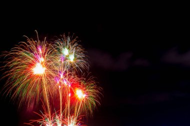 Deniz sahilinde güzel renkli havai fişek gösterisi, harika bayram havai fişekleri partisi ya da karanlık gökyüzündeki herhangi bir kutlama etkinliği..