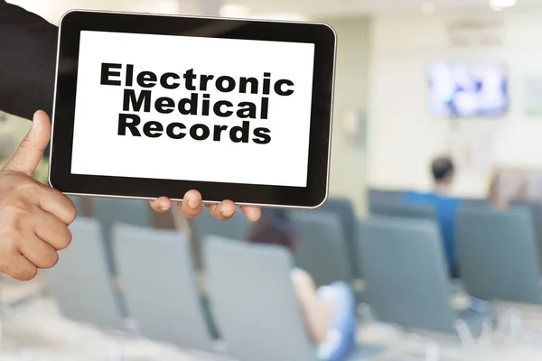 Medical record system show on tablet in someone hand on blur hospital background.