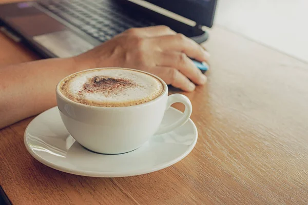 カフェでコーヒーマグカップとノートパソコン付きの木製カウンターバーで働くフリーランス — ストック写真